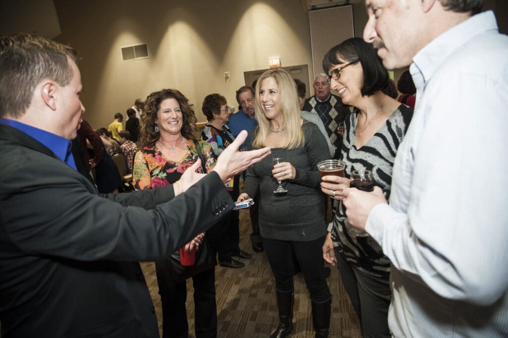 David Farr performing close-up magic for guests at a reception